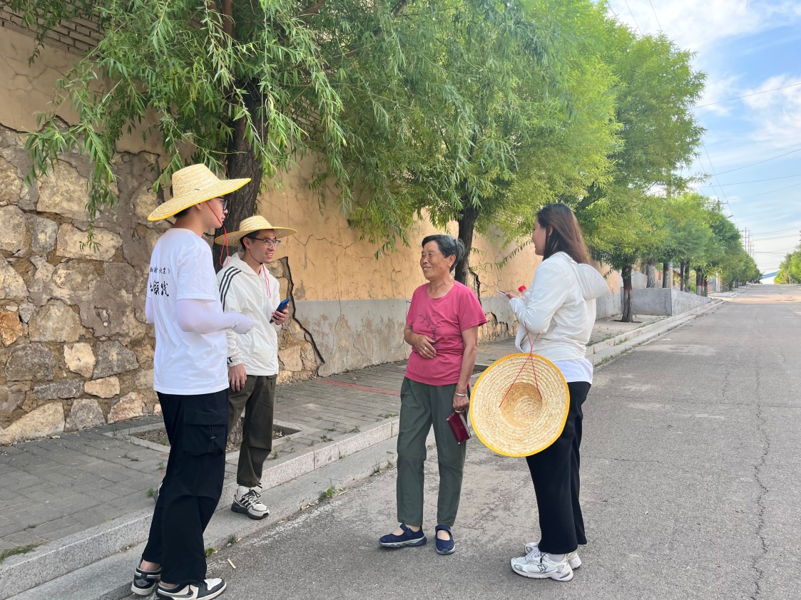 國(guó)土整治與生態(tài)修復(fù)實(shí)踐調(diào)研團(tuán)師生與村民交流。校方供圖